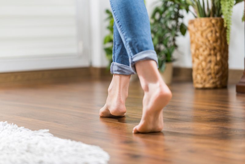 Young woman walking in the house on a wood floor. Gently walked the wooden panels.